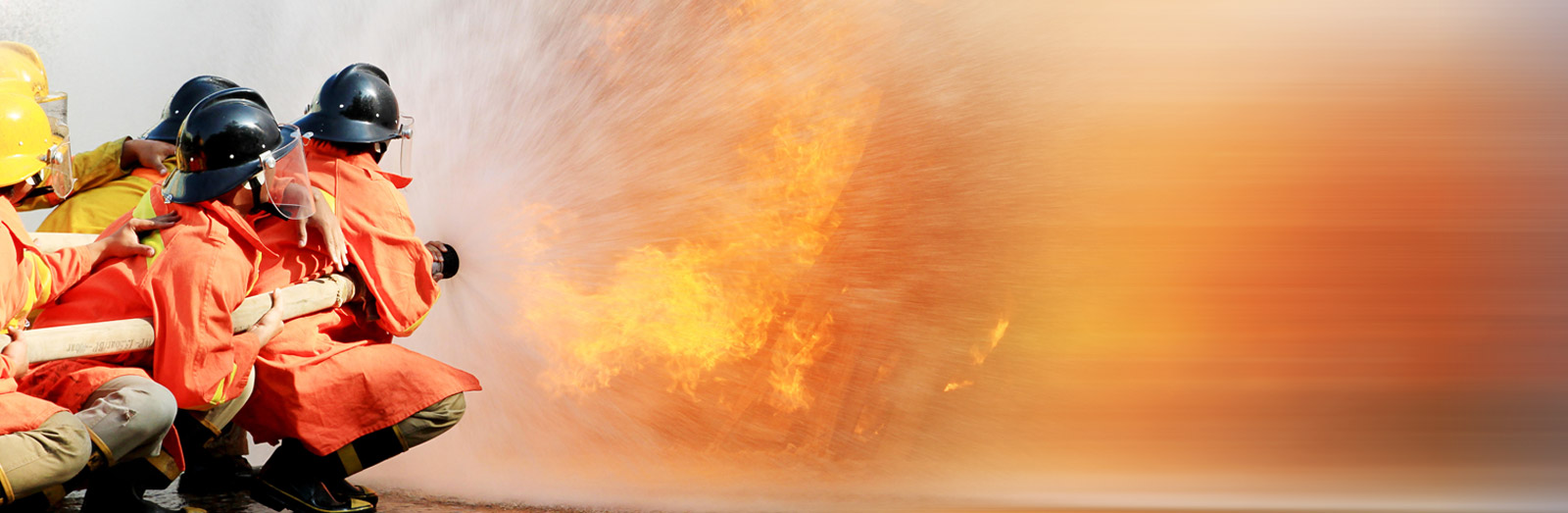 fire fighters holding a hose and putting off a fire